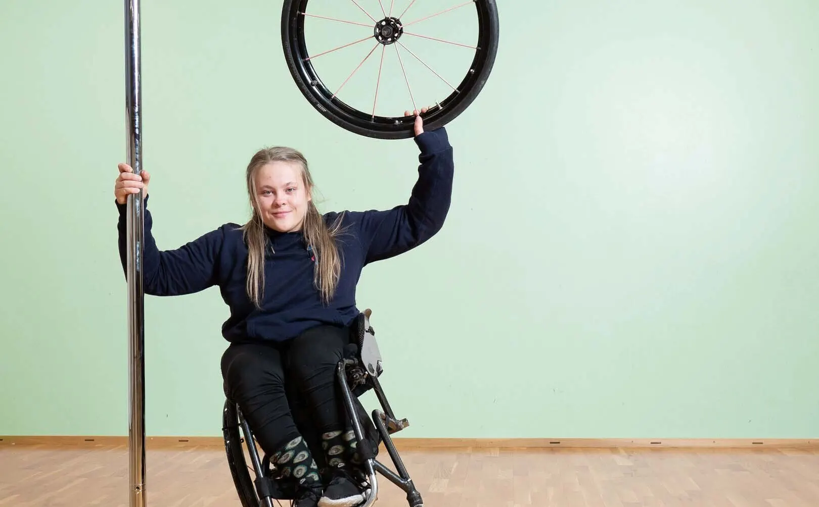 Sini Paukkeri poseeraamassa kameralle vihreää taustaa vasten.